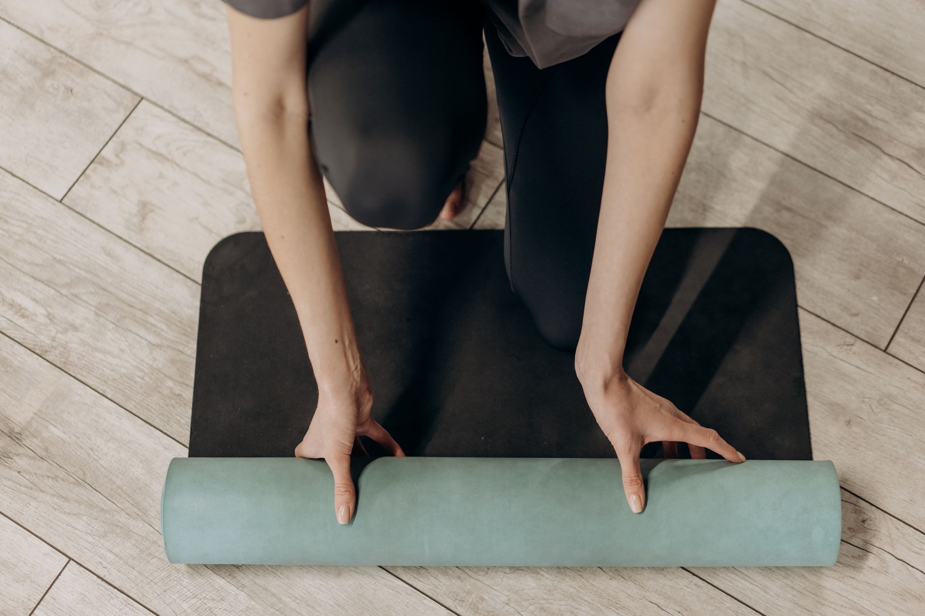 Person rolling a yoga mat